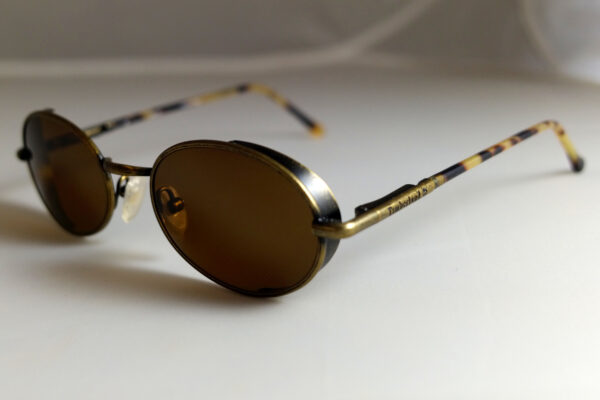 Sunglasses with a gold metallic frame and dark brown lenses