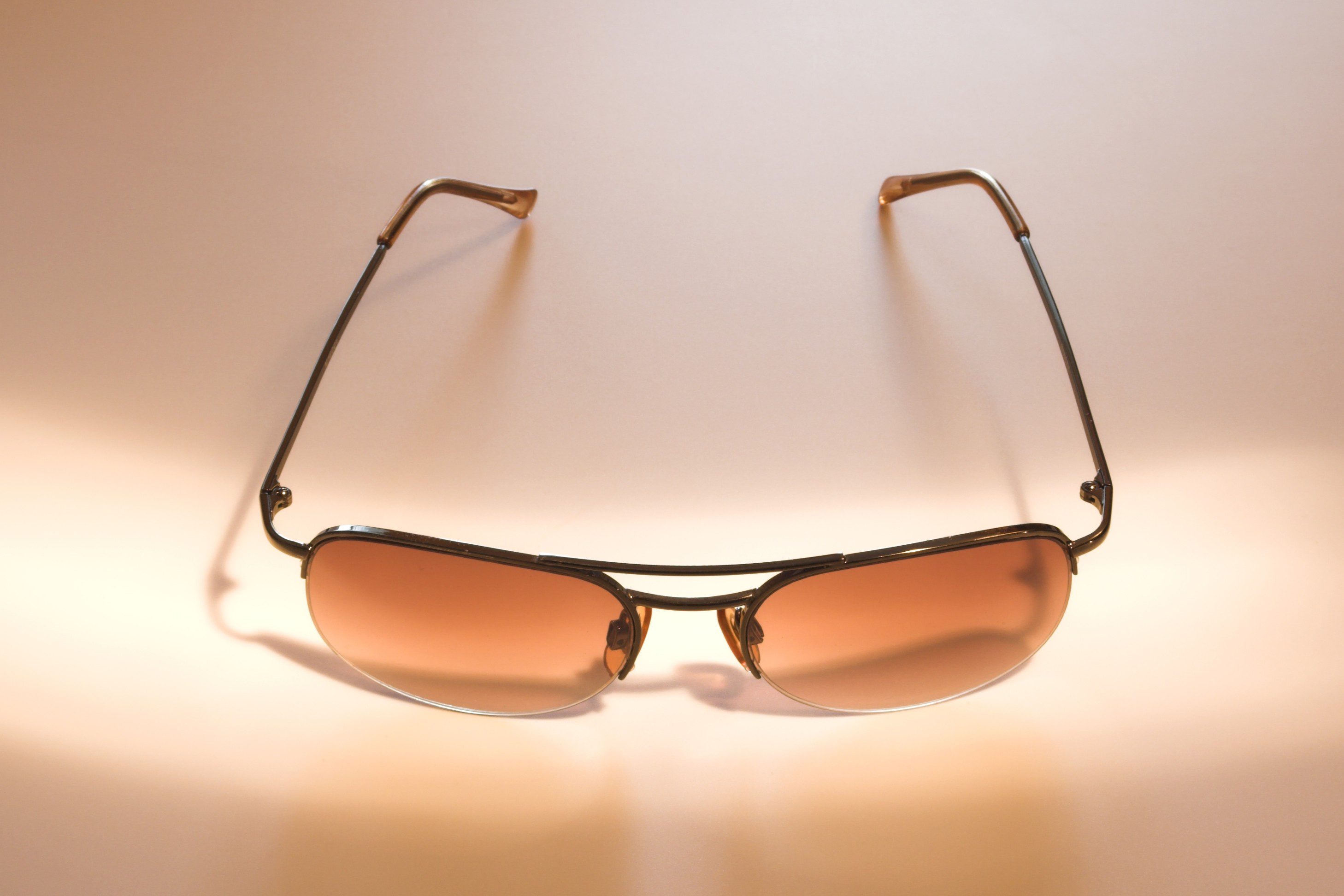 Brown-tinted sunglasses under warm light